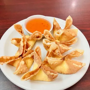 a plate of wontons with dipping sauce