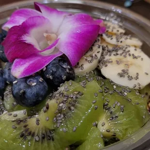 a bowl of fruit and a flower