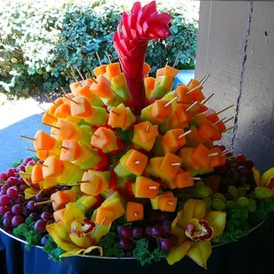 Fruit Skewers, arranged with Grapes and Orchids on platter.  (This event was outdoors in a park setting.)
