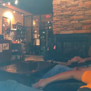 a man and a woman sitting in front of a fireplace