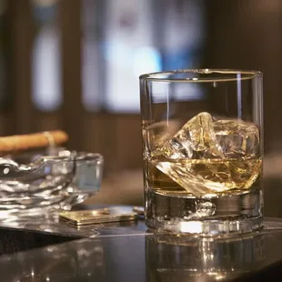 a glass of whiskey and a cigar
