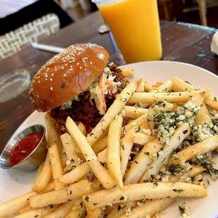 Pulled pork sandwich with garlic fries and orange juice