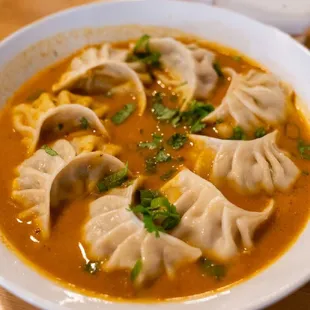 a bowl of soup with dumplings