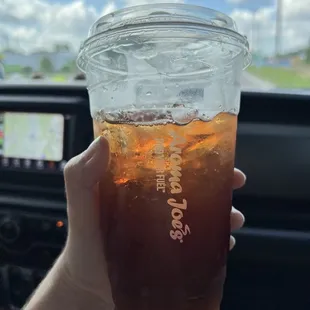 a hand holding a cup of iced coffee