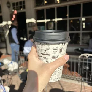 a hand holding a coffee cup
