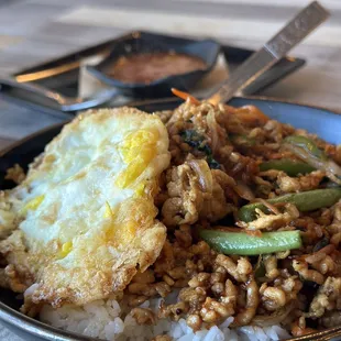 Pad Kra Pao rice bowl with Prik Nam Pla in background.