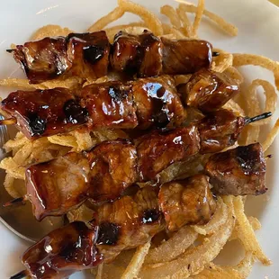 skewered meat on a white plate