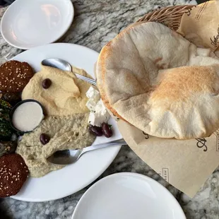 Mediterranean combo platter Sample of humus, baba ganush, tabbouleh, falafel, grape leaves &amp; feta, with tahina and pitas