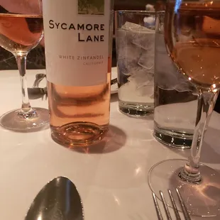 a bottle of sycamore and two glasses of wine