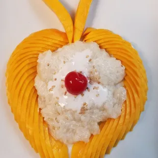 a white plate topped with rice and mango slices