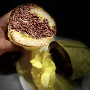 a hand holding a sandwich