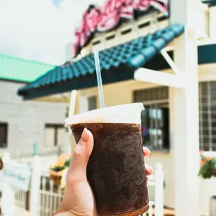 a hand holding a drink