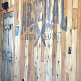 a wooden wall with a sign that reads arsenal cider house