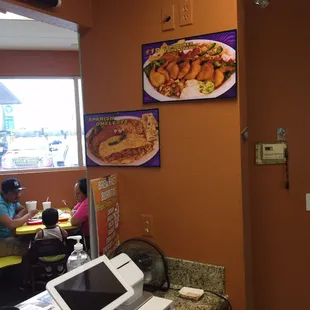 a restaurant with a counter and a menu on the wall
