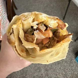 a hand holding a burrito