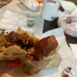 Thick piece o bacon in breakfast burrito- meat, eggs, cheese, potato