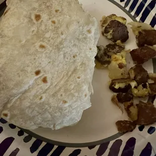 Dry tasteless breakfast burrito with hard overcooked old meat