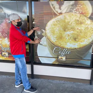 a man wearing a face mask and holding a cup of coffee
