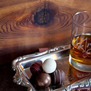 a glass of whiskey and chocolate truffles