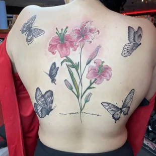 Color tattoo on back of butterflies and lily flowers