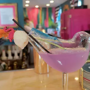 a purple cocktail in a glass