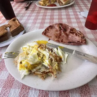 Breakfast: two eggs over hash browns with ham.