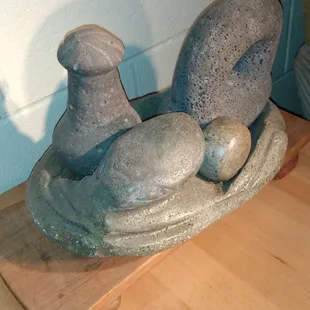 Set of Hawaiian stones Poi Pounder, Ring Pounder and ulumaika  sits  on a stones bowls with carved squid on it