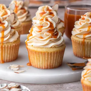 a plate of cupcakes with caramel frosting