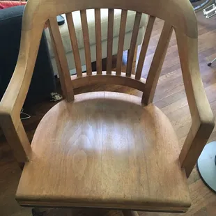 Chair 2, before refinishing -- wear and tear, remnants of white paint I had awkwardly scraped off, broken casters that were not original.