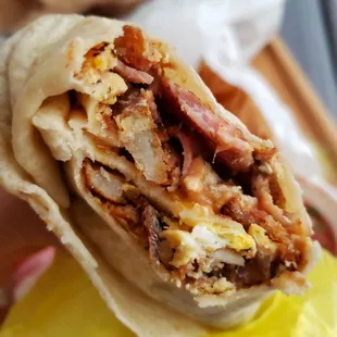 Breakfast burrito with bacon, ham, and sausages along with the usual eggs, beans, cheese, and potatoes