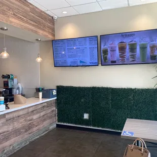 a coffee shop counter with a menu on the wall