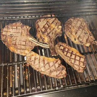 steaks cooking on the grill