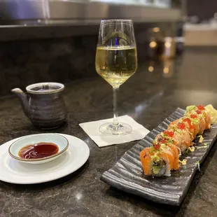 a plate of sushi and a glass of wine