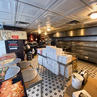 a kitchen with pizzas