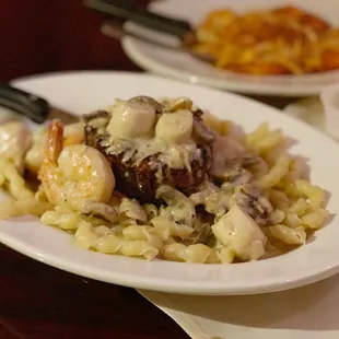 a plate of pasta with shrimp and mushrooms