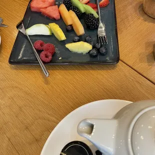 a plate of fruit and a teapot