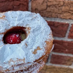 a pastry with powdered sugar and a strawberry