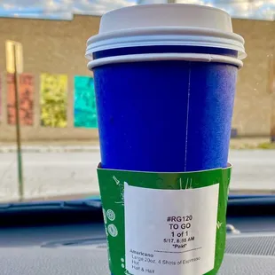 a cup of coffee on a car dashboard