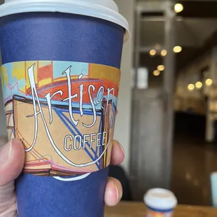 a hand holding a cup of coffee