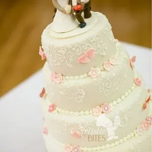 a wedding cake with a bride and groom on top