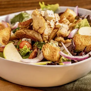 a bowl of salad with croutons