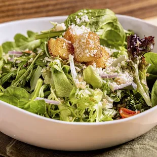 a bowl of salad with croutons