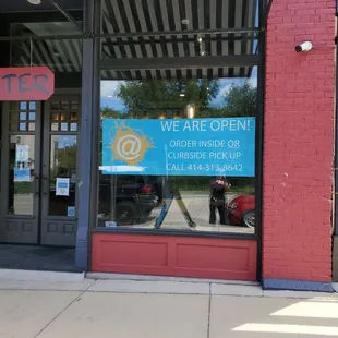 a storefront with a sign that says we are open