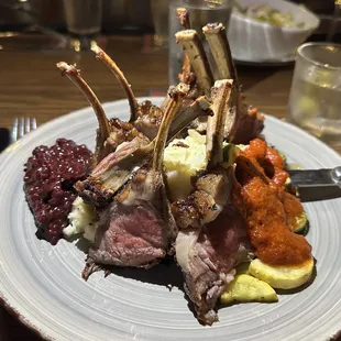 Rack of lamb with berry sauce, mashed potatoes and vegetables.