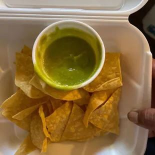 a bowl of guacamole and tortillas