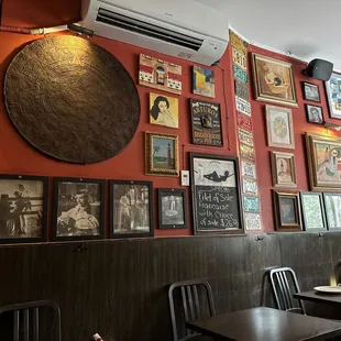a dining room with red walls and pictures on the wall