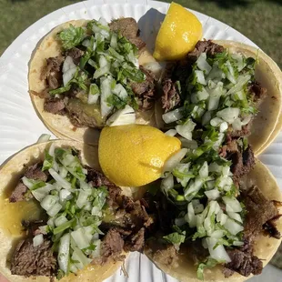 a person holding a plate of tacos