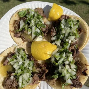 a person holding a plate of tacos