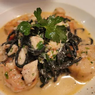 a plate of pasta with shrimp and spinach