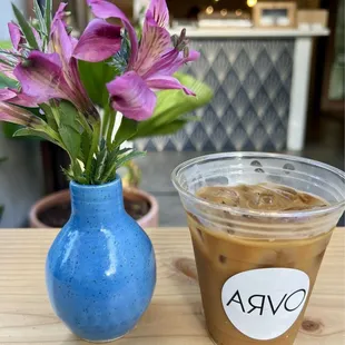 a cup of coffee and a vase of flowers